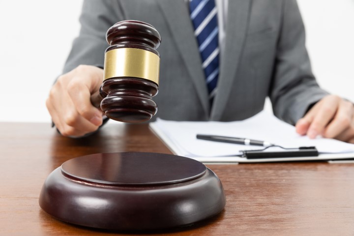 closeup shot person with gavel hand papers table 720x480 1